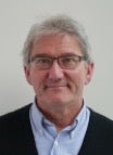 Man with grey hair and glasses, wearing a light shirt and black cardigan; Dr Steve Beyer