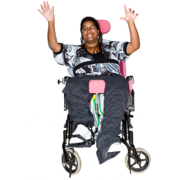 A woman in a wheelchair has her hands raised smiling