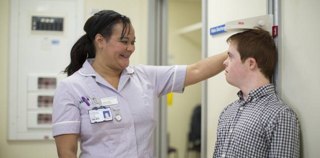 A nurse measuring the height of a patient