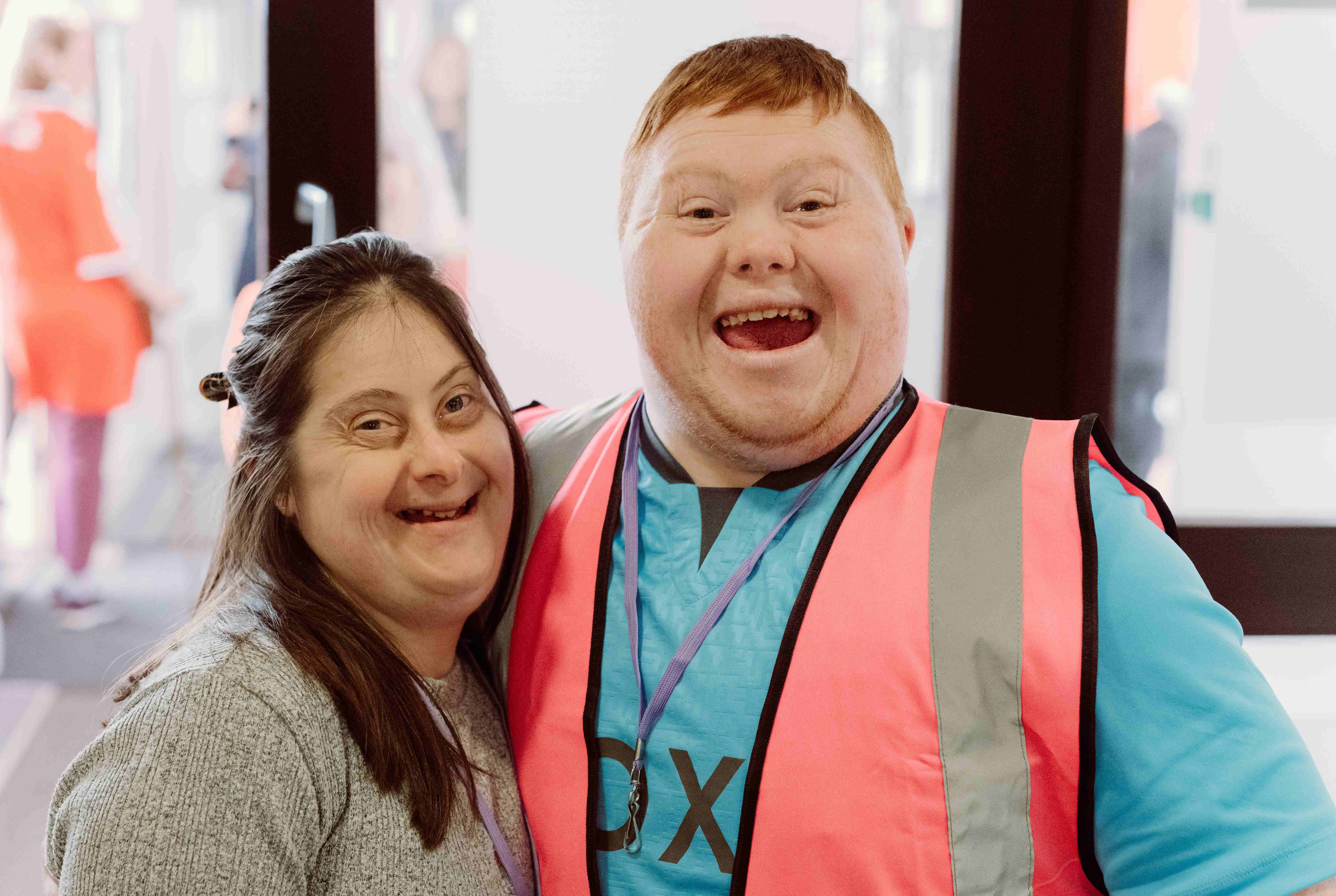 A man and woman with downs syndrome smiling at the camera