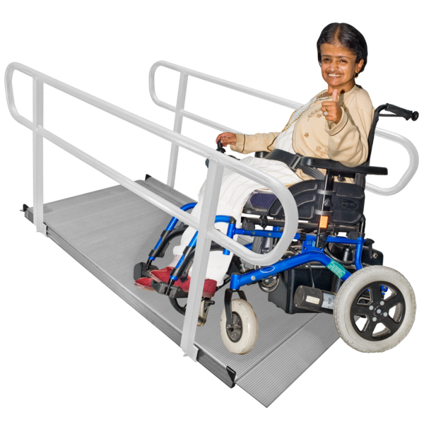 A woman in a wheelchair about to use a ramp to access a building. She has her thumbs up