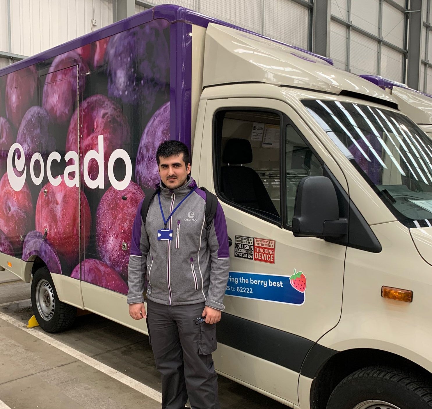 Niav is standing next to an Ocardo van as part of a work placement
