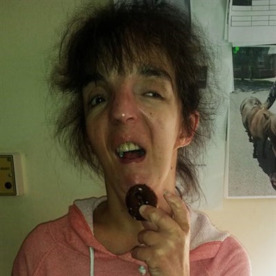 Woman with brown hair holding a biscuit near her mouth