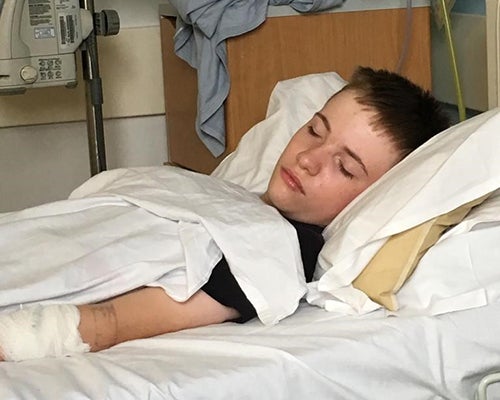 Young man asleep in hospital bed.