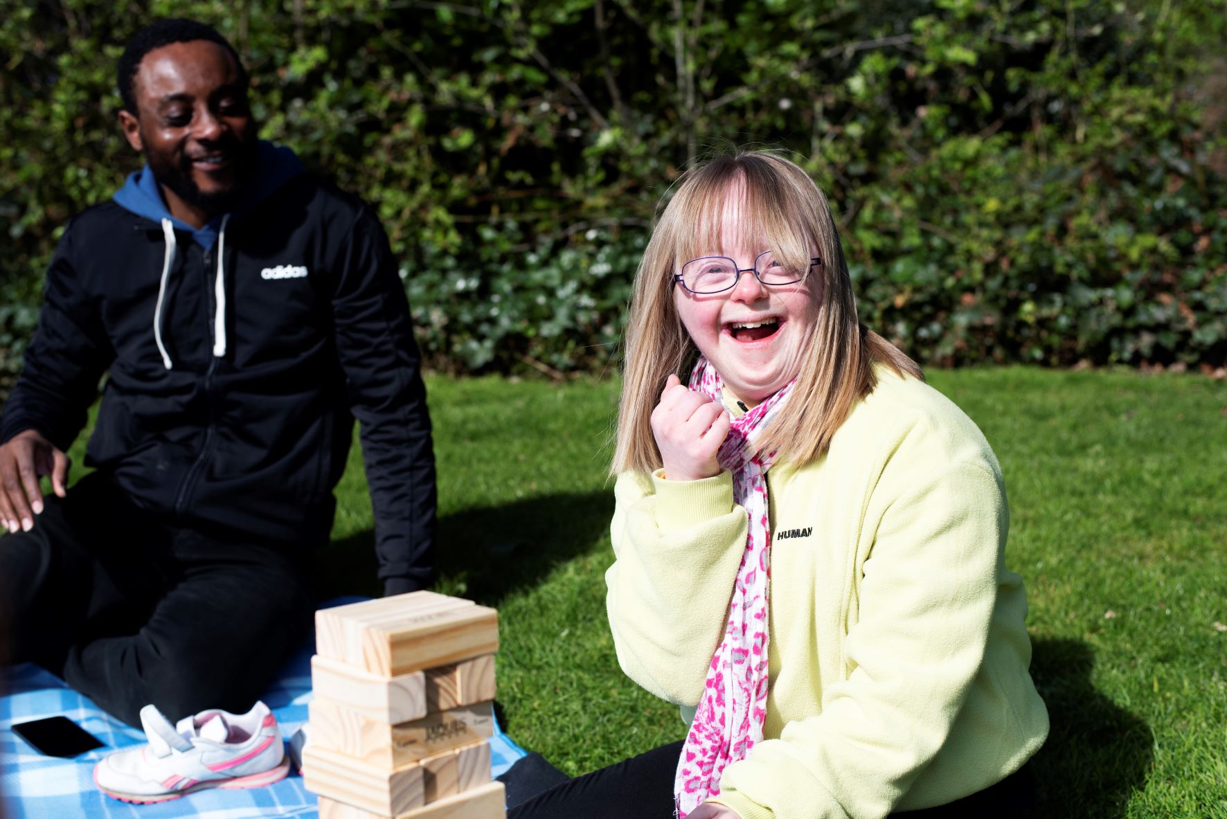 A male volunteer on a picnic with a girl with down's syndrome