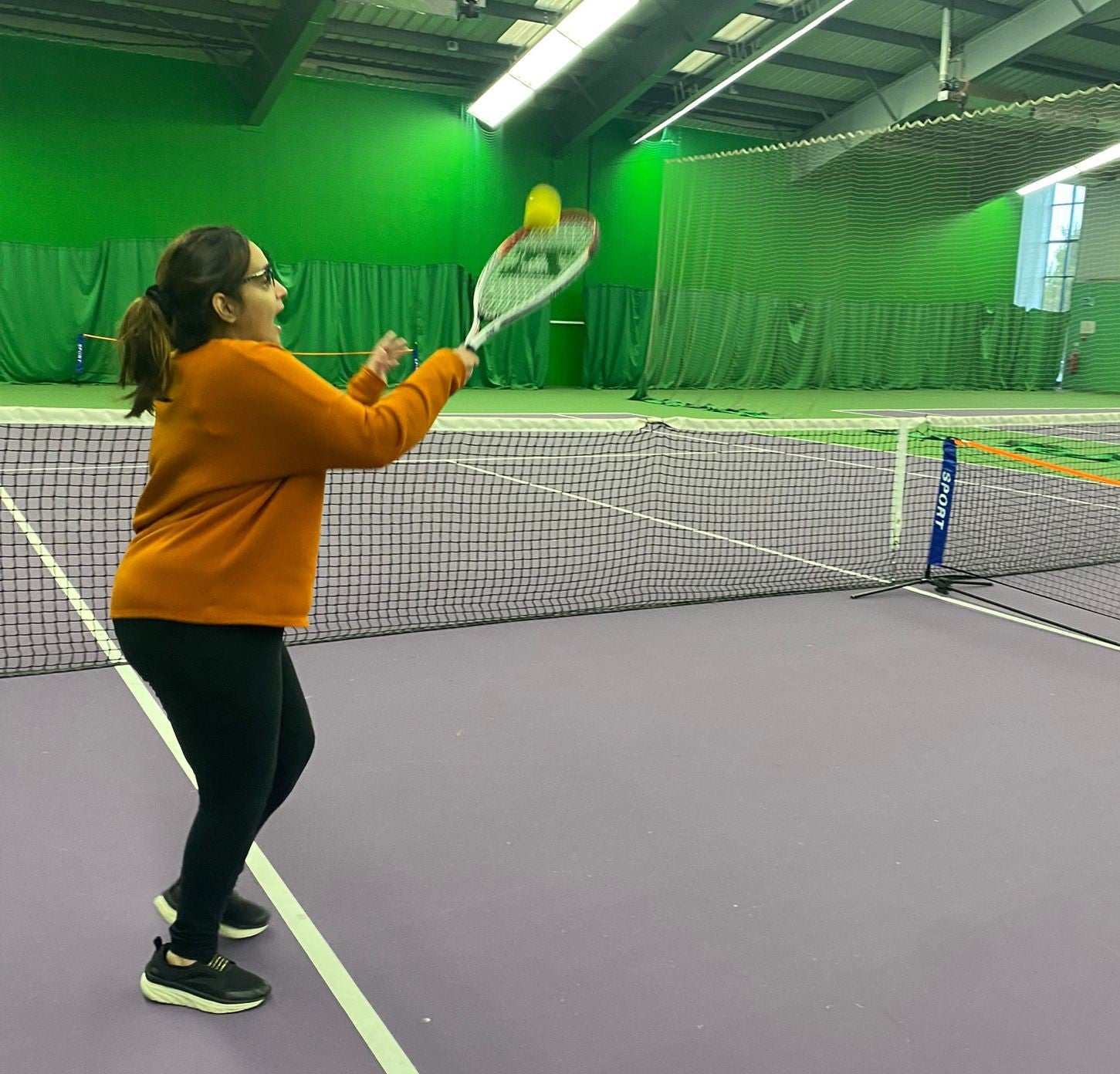 Woman playing tennis on an indoor court