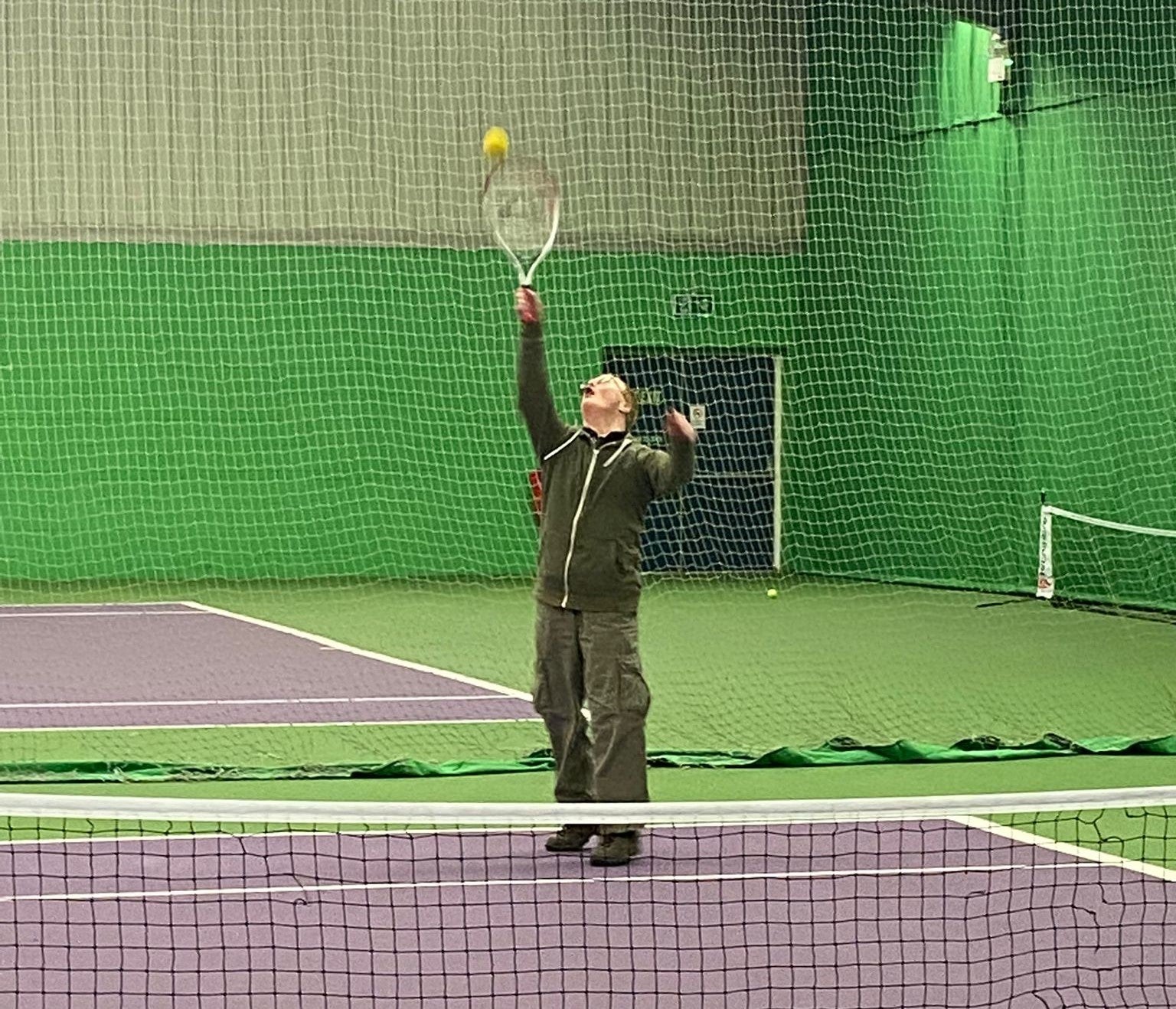 Man playing tennis on an indoor court