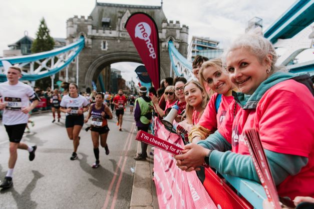 People running the London Marathon being cheered on by Mencap supporters