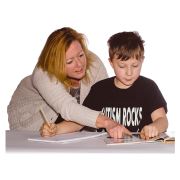 An adult lady helping a boy complete schoolwork