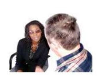 a woman sitting down talking to someone 