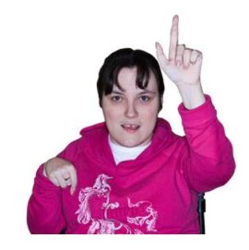 A woman with her hand raised to ask a question