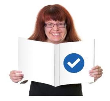 A smiling woman reading a book with a tick symbol on the front cover