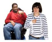 A man in a wheelchair pointing at his chest and a woman standing up, also pointing at her chest