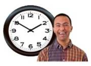 A smiling man next to a clock