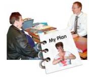 A woman sitting across a desk from a doctor with a My Plan book