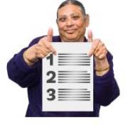 A woman holding up a list with her thumbs up