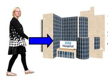 A woman walking towards a hospital