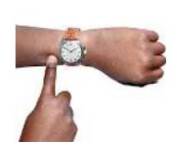 a finger pointing to the time on a wrist watch