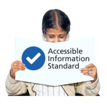A woman reading the Accessible Information Standard book with a tick on the cover