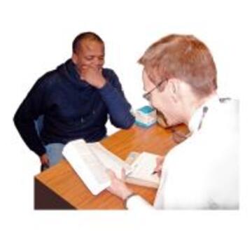 A patient sitting in front of a doctor at a desk talking