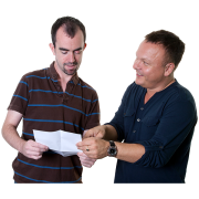 A man explaining something to another man holding a piece of paper