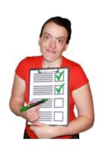 A woman using a pen to point to a list with green ticks on it 
