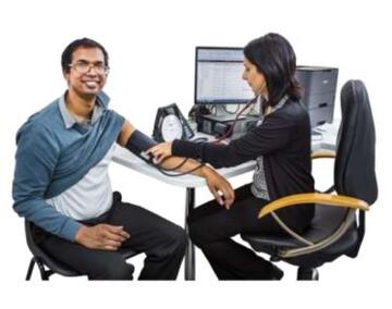 A doctor taking a mans blood pressure at a desk
