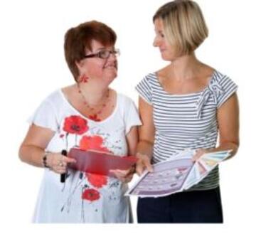 A woman showing another woman some leaflets