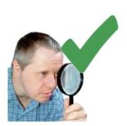 A man using a magnifying glass with a green tick symbol next to him