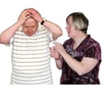 A man with his hands on his head looking uncomfortable as a woman tries to talk to him