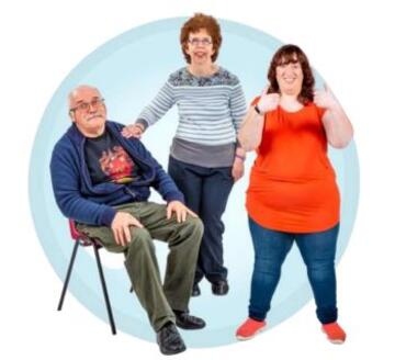 A group of people - two women standing and a man sitting down