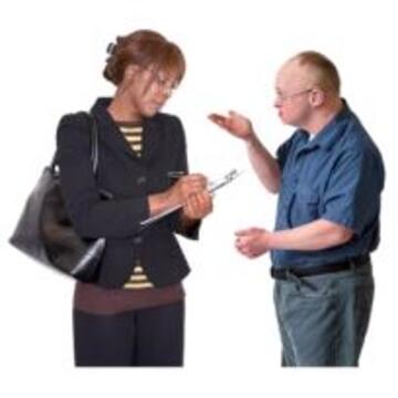 A man explaining something to a woman with a clipboard