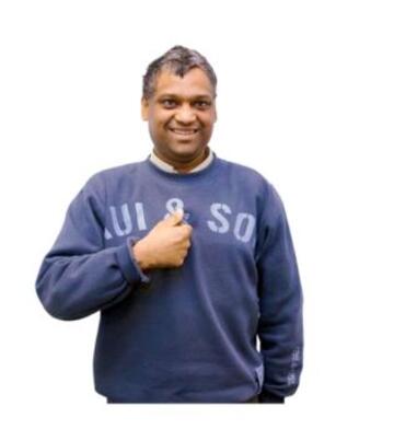 A man with his thumbs up smiling