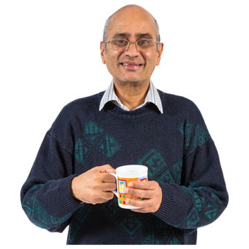 A man smiling holding a mug.
