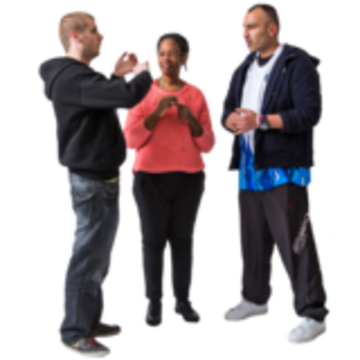 A group of people talk to each other, standing in a circle and facing one another