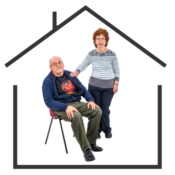 A seated man and a standing woman with her hand on the mans shoulder inside a house 