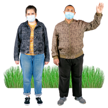 Two people with facemasks standing outside. One is waving.
