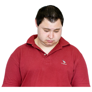 A man in a red to with his head lowered and looking sad