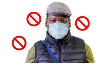 A man wearing a face covering with 'no entry' signs around his head