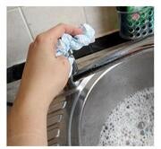 A hand turning off a tap using a paper towel