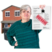 A woman outside her house holding up a council tax bill which is overdue