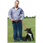 A man walking his dog in an open field