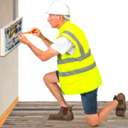 a repair man working on the electrics in a wall