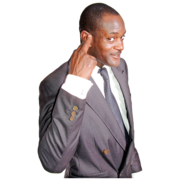 A man in a suit pointing to his ear and smiling