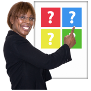 A woman manager pointing to a white question mark on a blue background. On the card is also three other coloured squares with white question marks on them. One is red, another is  yellow and the third is green.