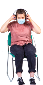 A lady sitting on a chair wearing a facemask and putting on some headphones.