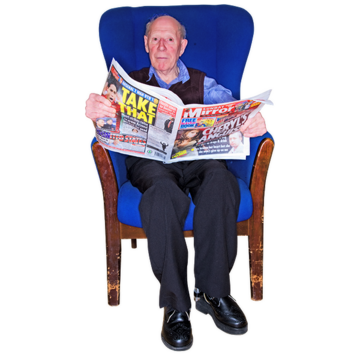 A man sitting in a chair reading a newspaper