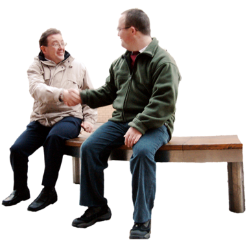 Two men sitting on a park bench shaking hands