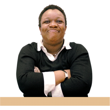 A woman with her arms folded smiles at the camera.