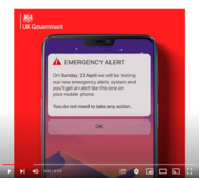 A mobile phone with an emergency alert message on the screen